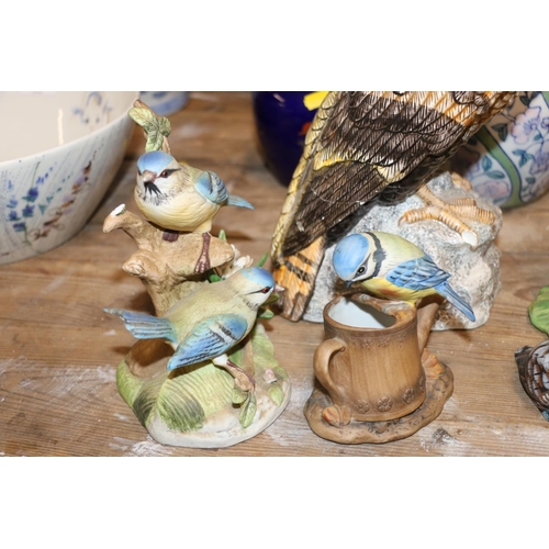 106 - Ceramic model of a bird of prey and four other bird models, largest 27cm.