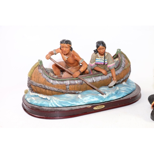 133 - Two resin Native American figures of a sitting chief and canoe, largest 29cm high.