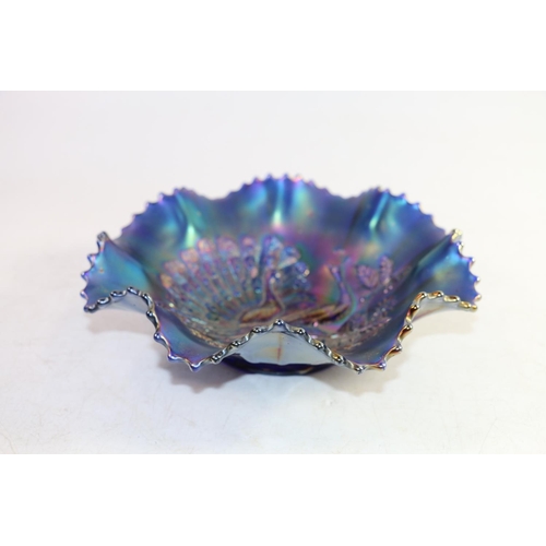 137 - Early 20th century blue iridescent carnival glass frilled bowl with peacock on fence design, 20cm wi... 