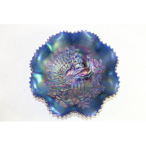 137 - Early 20th century blue iridescent carnival glass frilled bowl with peacock on fence design, 20cm wi... 