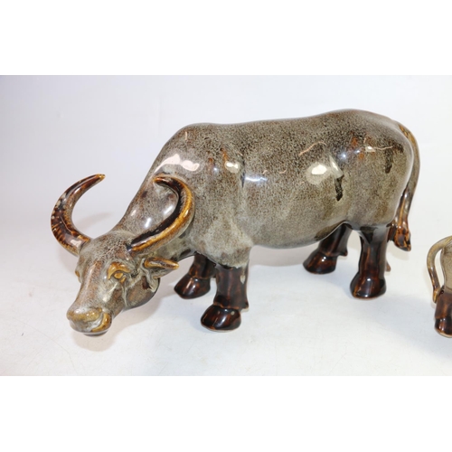 139 - Two drip mottled glaze ceramic models of water buffalo, largest 36cm long.  (2)