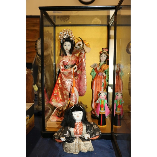 156 - Japanese felt faced doll of a geisha in traditional dress and other similar dolls, in display case 5... 