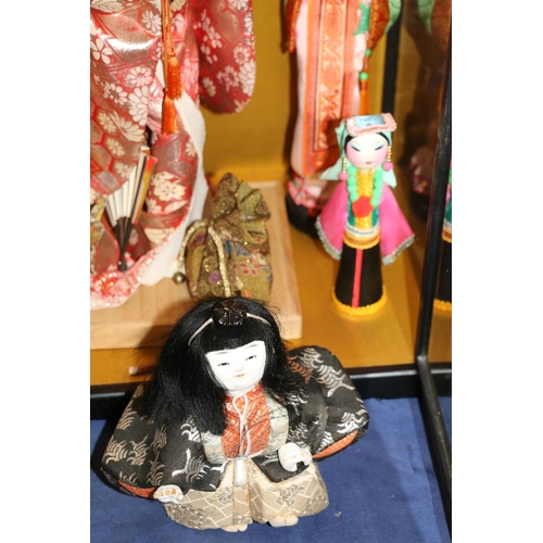 156 - Japanese felt faced doll of a geisha in traditional dress and other similar dolls, in display case 5... 