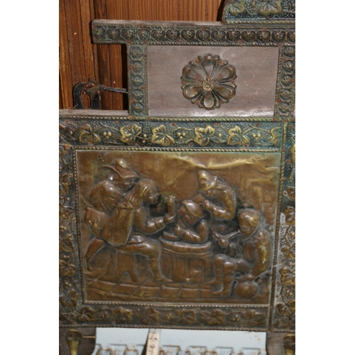 215 - Brass and glass hall mirror with integral hooks, decorated in relief with tavern scenes.