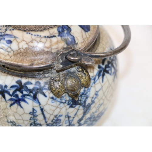 246 - Oriental blue and white pottery pot with metal handle and metal mounts in the form of hanging bats, ... 