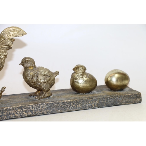 274 - Gilt cast resin model group of evolving cockerels from egg to chicken, 57cm long.