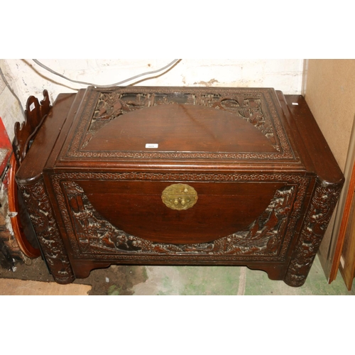 669 - Burmese hardwood chest with carved landscape and figural decoration, 100cm.