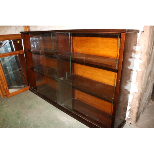 673 - Mahogany effect three shelf wall display cabinet with sliding glazed doors, 122cm wide.