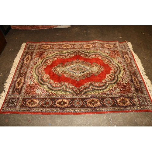 714 - Persian rug, rust red ground with repeating floral scrolls, 190cm x 140cm.