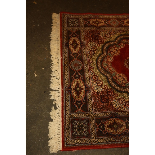 714 - Persian rug, rust red ground with repeating floral scrolls, 190cm x 140cm.