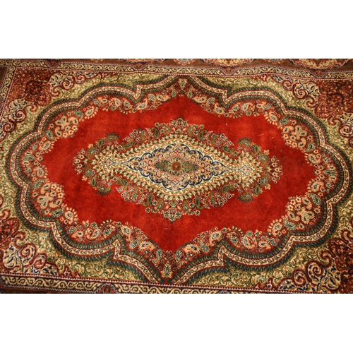 714 - Persian rug, rust red ground with repeating floral scrolls, 190cm x 140cm.