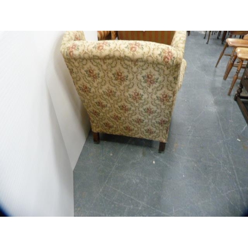 287 - Antique upholstered wing armchair on later brass castors.