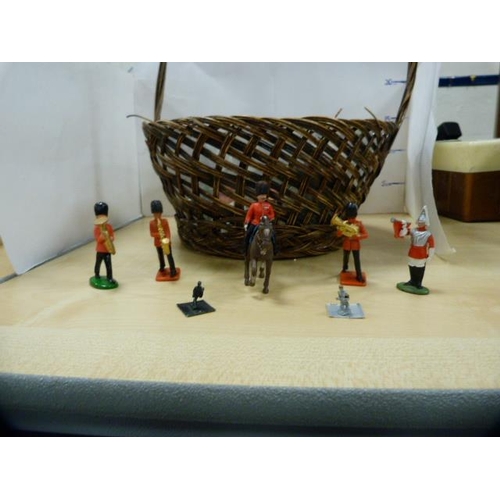 76 - Basket containing assorted toy soldiers and accessories.