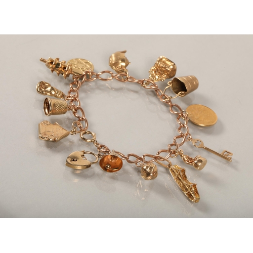 74 - 9 ct gold Charm bracelet with various charms to include gold half sovereign .38 grams