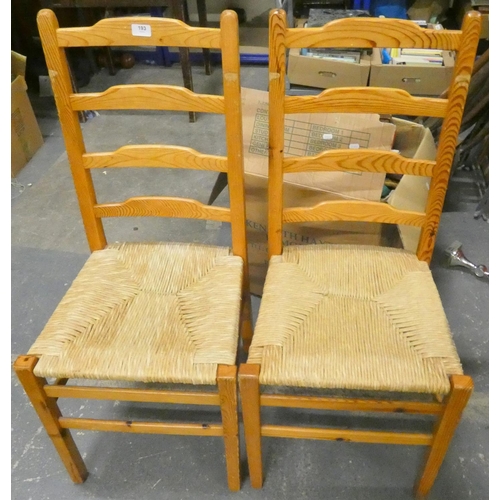 193 - Two ladder back, rush seat, pine dining chairs.