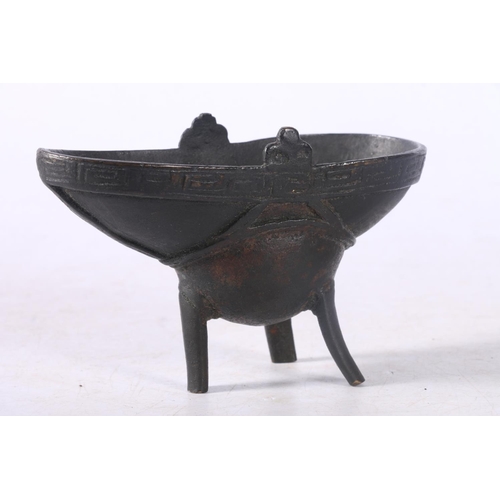 103 - Chinese cast bronze libation cup of typical form with Greek Key style border, raised on three suppor... 