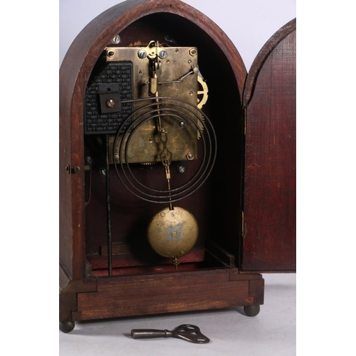 108 - Mahogany cased arch-top mantel clock decorated with faux inlaid flower to front, 30cm high.