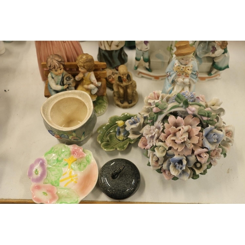 122 - Decorative ceramics to include a Nao figurine, a miniature curling stone, a floral posy, etc.