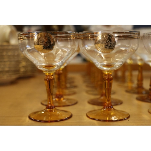 140 - Amber and clear drinking glasses with gilded coin decoration.