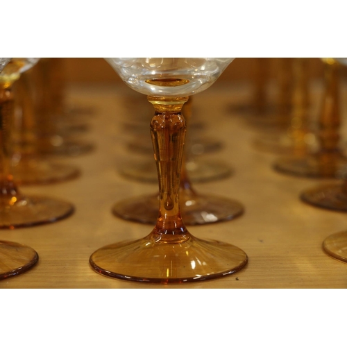 140 - Amber and clear drinking glasses with gilded coin decoration.