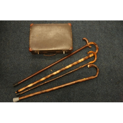 200 - Vintage leather case and four walking sticks.