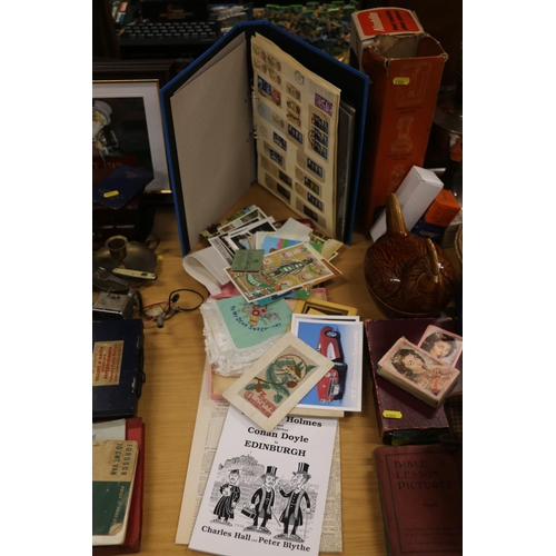 219 - Postcards, stamps and ephemera to include silk embroidered cards, a book 'Sherlock Holmes in Edinbur... 