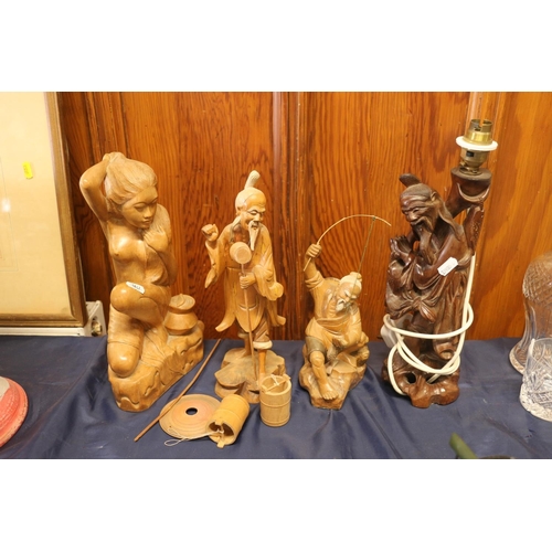 24 - Carved treen model of female and three oriental carved hardwood figures, one converted to a table la... 