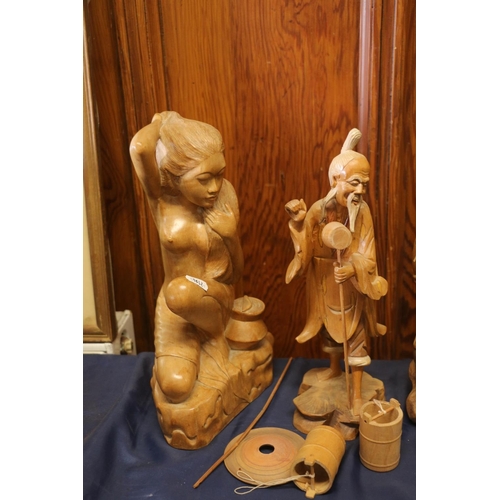 24 - Carved treen model of female and three oriental carved hardwood figures, one converted to a table la... 