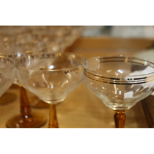 140 - Amber and clear drinking glasses with gilded coin decoration.