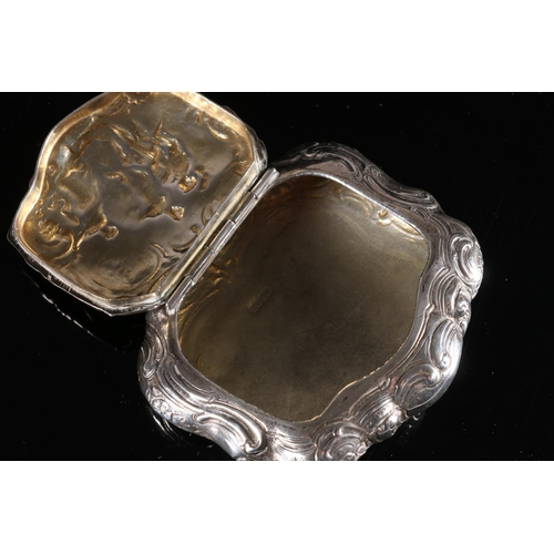 102 - Continental silver table tobacco box of cartouche form, the hinged cover decorated in relief with cl... 