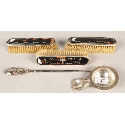 187 - Silver tea strainer , silver handled button hook and three silver and tortoise shell brushes