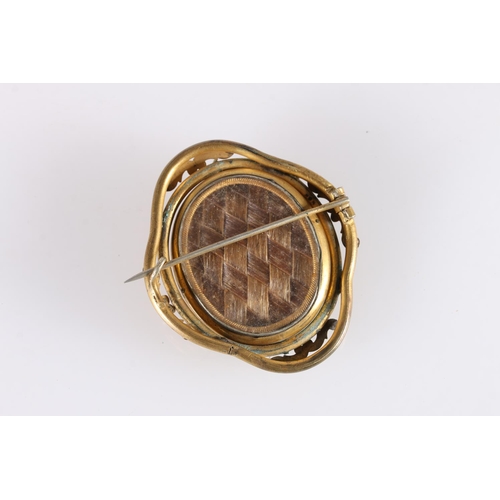 524 - Late Victorian cameo shell brooch in pinchbeck mount, the rear with glazed panel containing woven ha... 