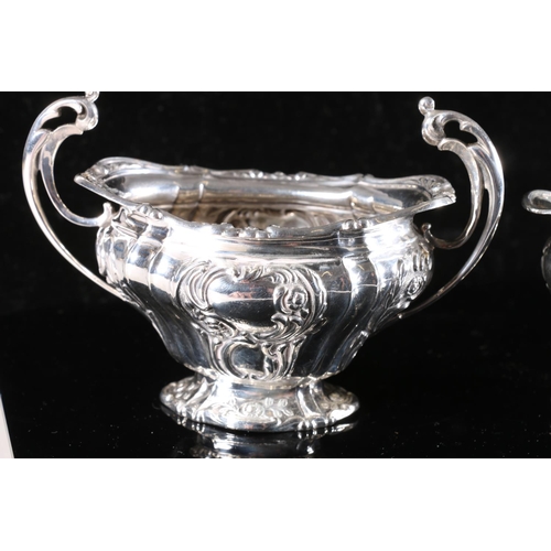 574 - Victorian silver cream jug and matching sugar, scrolled handles with rococo embossed design to the b... 