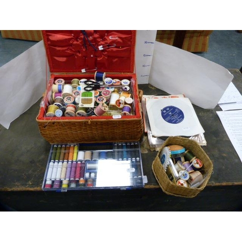 167 - Spools of thread in a wicker box and a small group of 7in vinyl records.