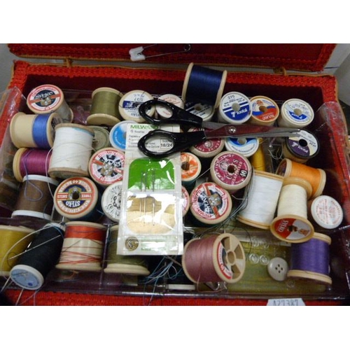 167 - Spools of thread in a wicker box and a small group of 7in vinyl records.