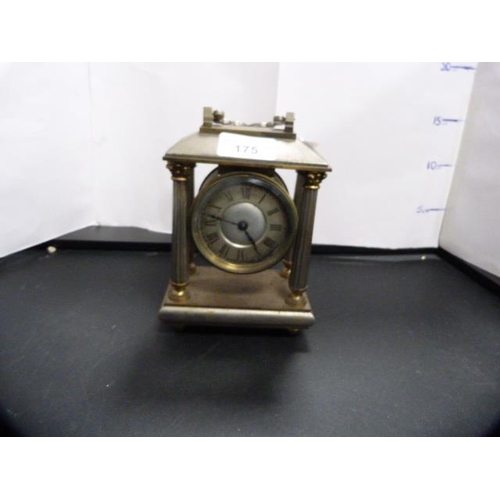 175 - Antique metal Corinthian-style mantel clock with silvered dial.