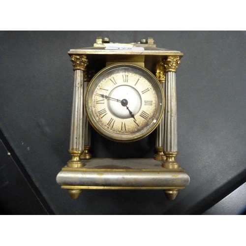 175 - Antique metal Corinthian-style mantel clock with silvered dial.