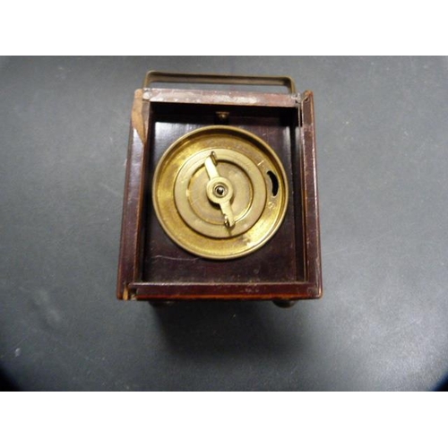 176 - Desk or travel clock in a stained wood case, c. early 20th century.