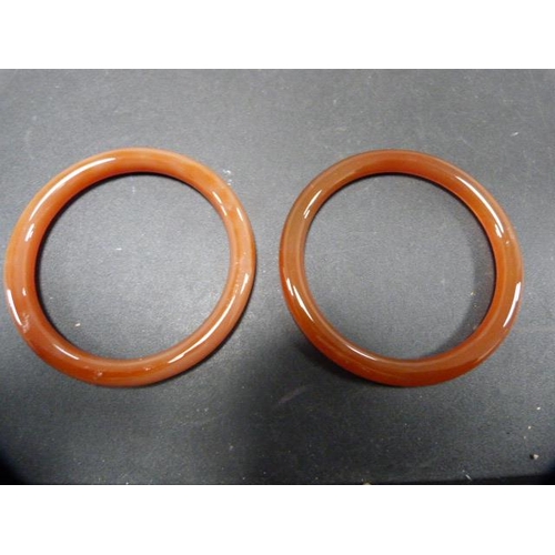 235 - Three Oriental-style hardstone bangles.