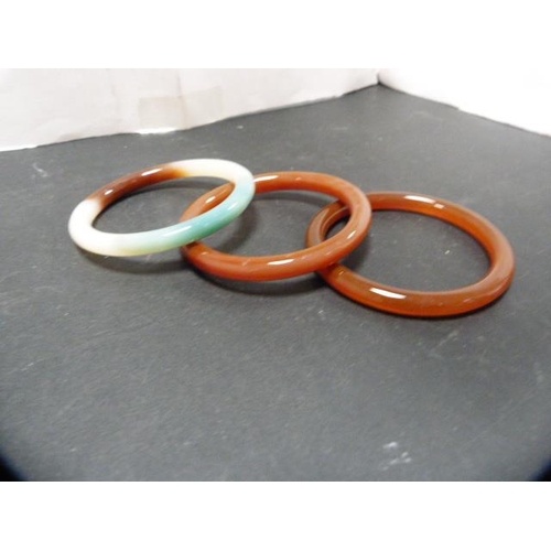 235 - Three Oriental-style hardstone bangles.