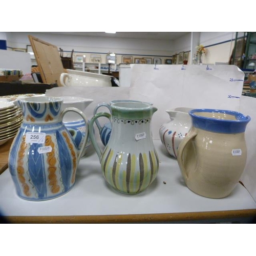 256 - Five assorted Buchan jugs and another jug.  (6)