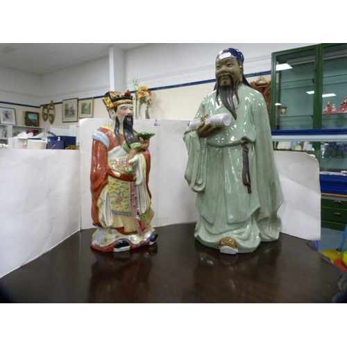 67 - Two Oriental ceramic figures modelled as sages, one holding a scroll.  (2)