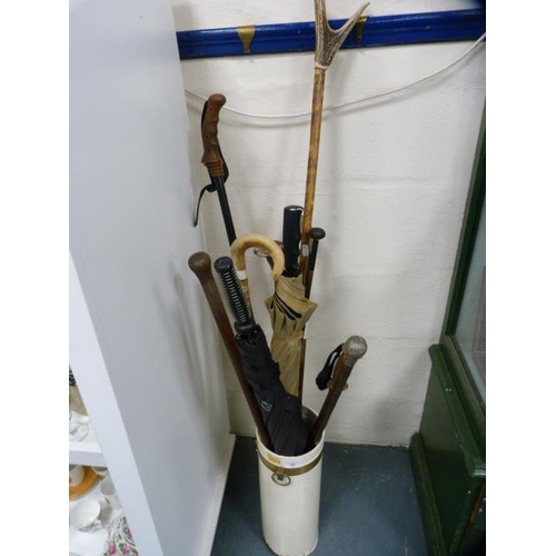 82 - Stick stand containing assorted walking sticks and umbrellas.