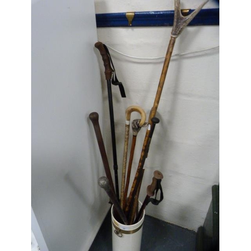 82 - Stick stand containing assorted walking sticks and umbrellas.