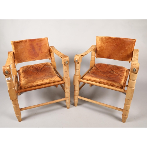 598 - Pair of 20th century Indian easy chairs of teak construction with stretched leather back and arm res... 