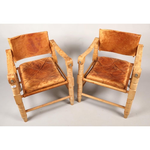 598 - Pair of 20th century Indian easy chairs of teak construction with stretched leather back and arm res... 