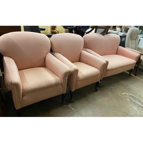 639 - Pink upholstered two seater sofa with pair of matching arm chairs, mahogany legs on casters (4)