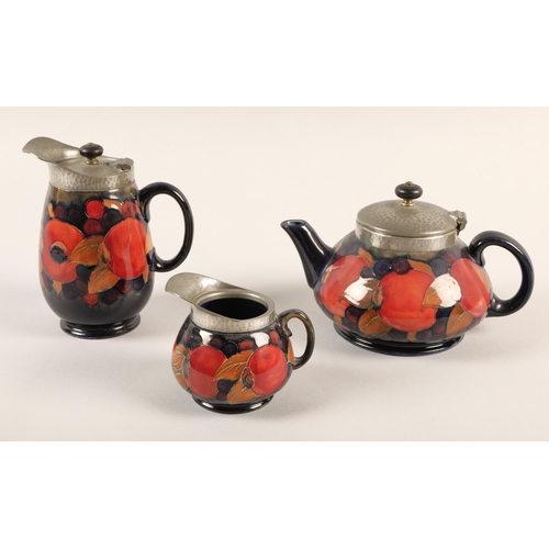 12 - Moorcroft pottery Tudric pewter three piece tea service, pomegranate pattern designed by William Moo... 