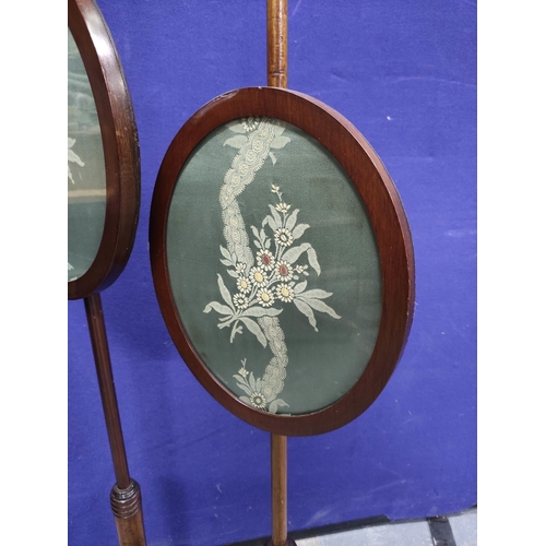 455 - Two 19th century pole screens with turned columns and finials with oval fabric panels on turned base... 