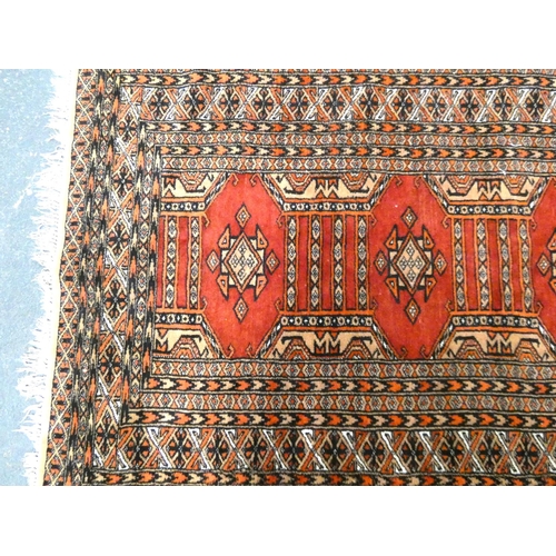 439 - Belouch rug with geometric medallions to the centre on red ground, with further motifs to the multi ... 